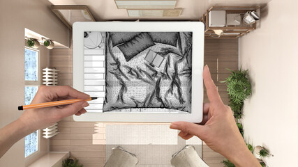 Hands holding and drawing on tablet showing wooden rustic bedroom details CAD sketch. Real finished interior in the background, architecture design presentation