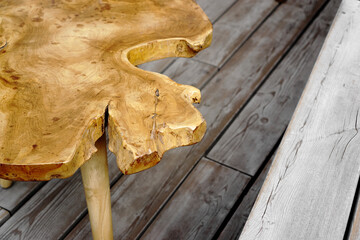 Slab coffee table close up. Furniture manufacture. Hand made coffee table. Wooden table on wood planks terrace.