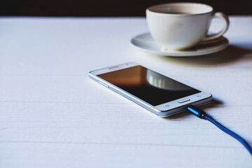 .Charge the mobile phone on the table.