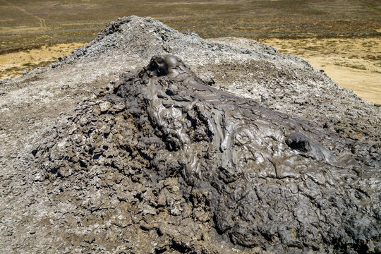 Close up view onto acting mud volcano. Mud is slowly flowing from crater. Shot near Kerch, Crimea