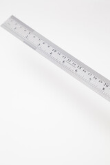 Angled stainless steel ruler with inches and centimeters on white