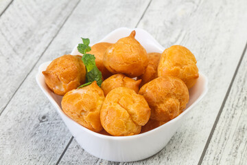 Sweet tasty profiteroles heap in the bowl
