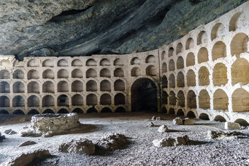 Remains of ancient constructions for wine storage, stone well on left side. Shot in Chaliapin Grotto (or Musical cave) near resort town Novyi Svit, Crimea