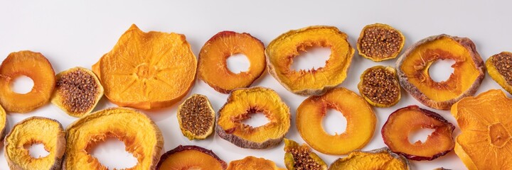 slices of dried persimmon, peach, plum and figs on a white background. dried fruits. eco.