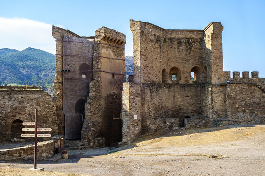 Main gate watch towers of Genoese fortress, Sudak, Crimea. They were built in XIV century in traditional Italian style. Translation of writings on pointer: 'City of makers, Temple with arcade, WC etc'
