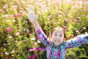 花畑で両手を上げる少女