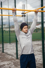 strong athlete does a pull-up on the crossbar.