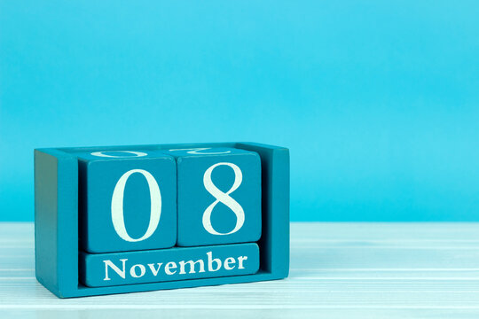wooden calendar with the date of November 8 on a blue wooden background, World Radiography Day; World Urban Development Day; International day of KVN