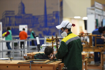 people in masks are working on projects indoors