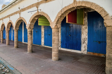 Traditional blue painted closed shop doors under the arcades.Alleyway in Essaouria...