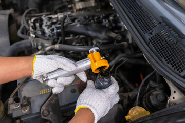 Diesel engine during service, or maintenance at the garage. Technical wear a glove and open the suction tube to analyze oil. Design of the old engine. Service, repair, and analysis concept