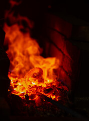 The metal spiral is heated to red in the forge in the forge during forging