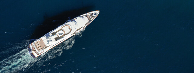 Aerial drone ultra wide photo of luxury yacht with wooden deck cruising in Aegean deep blue sea