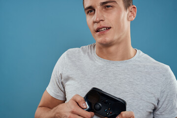A man with a joystick in his hands entertainment leisure technology video games blue background white t-shirt