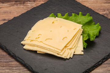 Sliced yellow cheese over board