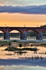 Late evening sunset view of old historic brick bridge over river Venta.