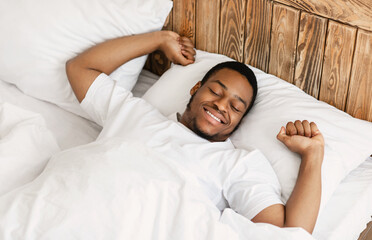 Cheerful Wellslept African Man Waking Up In Modern Bedroom