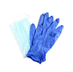 Medical gloves and protective face mask on white background, top view