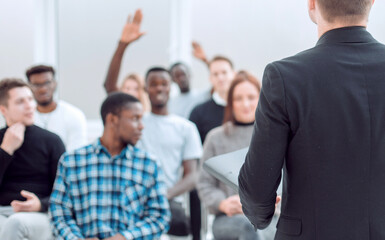 speaker and a group of diverse young listeners in a conference room