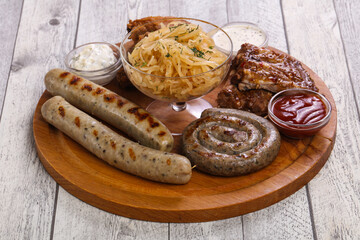 Meat plate with grilled sausages, ribs and chicken wings