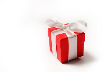 Red gift box with a bow on a white background with copy space.