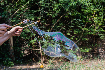 primer plano de manos haciendo grandes burbujas pompas de jabón cordoba argentina