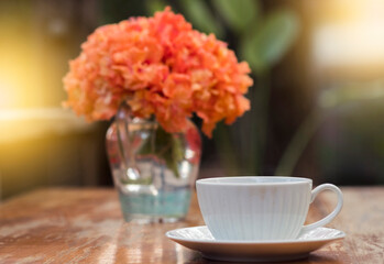A beautiful set of white coffee mugs on a wooden table in a natural setting in the morning.