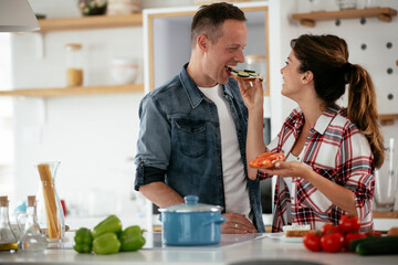 Young couple making sandwich at home. Loving couple enjoying in the kitchen.