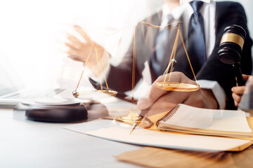 Business and lawyers discussing contract papers with brass scale on desk in office. Law, legal services, advice, justice and law concept picture with film grain effect