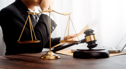 Business and lawyers discussing contract papers with brass scale on desk in office. Law, legal services, advice, justice and law concept picture with film grain effect