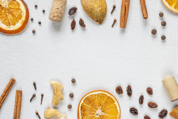 Ingredients for mulled wine on white background. Dried orange, cinnamon sticks, black pepper, cloves, dried ginger, wine cork. Top view, flat lay, copy space.