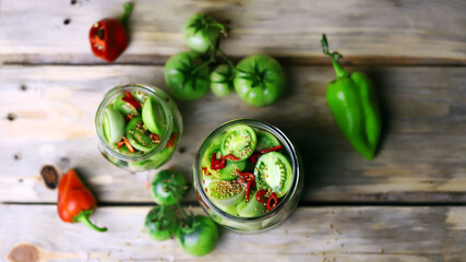 Selective focus. Jars of salted green tomatoes. Fermentation of green tomatoes. Pickles for the winter. Probiotics and fermented homemade foods.