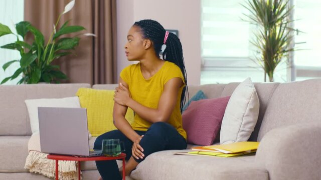 Unhappy surprised afro-american woman doing distant interview talking with family receiving bad news frustrating. Negative emotions. Sad woman wit laptop.