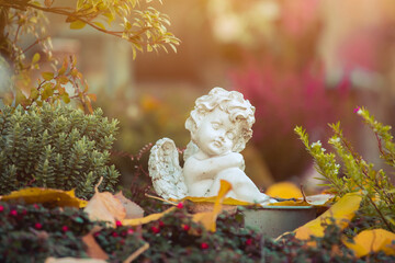 Remembrance concept: White angel on a grave, flowers