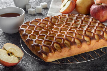 Apple pie with tea on a dark background with apples. Apple pie with apples