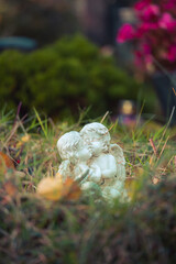 Remembrance concept: White angel on a grave, flowers