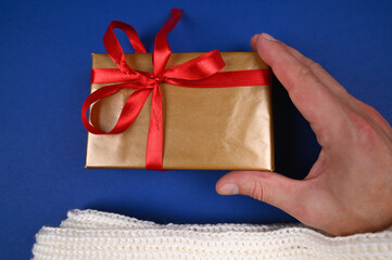 Hand holds gift wrap on blue background