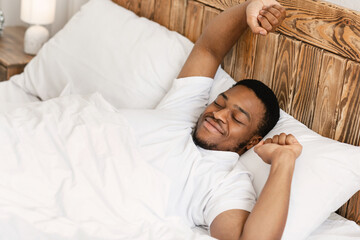 Rested Black Man Waking Up Lying In Bed At Home