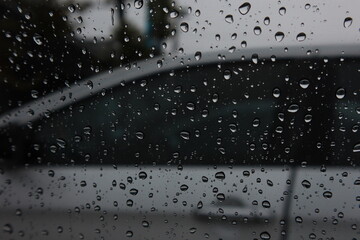 Naklejka na ściany i meble Rain drops adhere to the glass of the car on a rainy day