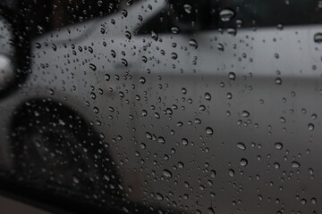 Rain drops adhere to the glass of the car on a rainy day