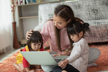 Fototapeta premium Mother and child daughter using laptop computer together in her house, education concept