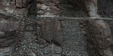 Face of cliff. Gray stone wall and old stone bricks. Texture and background of mountain. Wide and long stone banner.