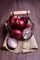 Raw red onions in a metal basket