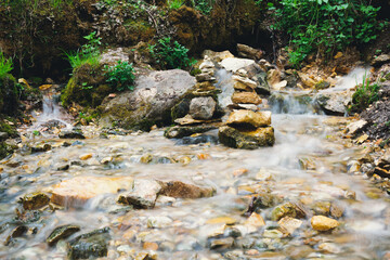 Stream in the forest. Springs streaming out of the ground. Small stone pebble stacks in the stream....