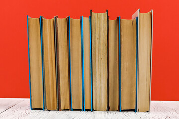 A stack of books on a white table on a red background
