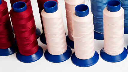 many spools with bright threads for machine sewing closeup on a white background with copy space