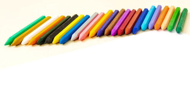 School concept.Multicolored wax crayons for children on white background with copy space.