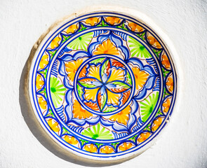 Traditional colorful wall decoration, hand-decorated ceramic plate hanging on the wall