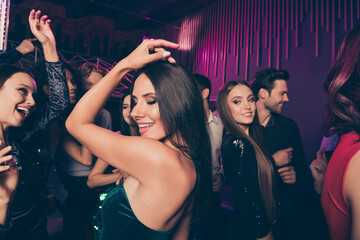 Photo of happy girl dancing at dance floor with friends chilling relaxing together enjoying music at corporate new year party with neon lights
