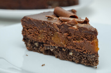 Digestive biscuit base with chocolate cheesecake and pockets of salted caramel sauce, topped with chocolate ganache, milk chocolate curls, and gold shimmer